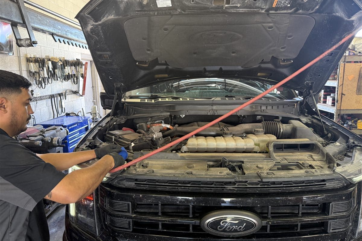 Technician performing an oil change under the hood